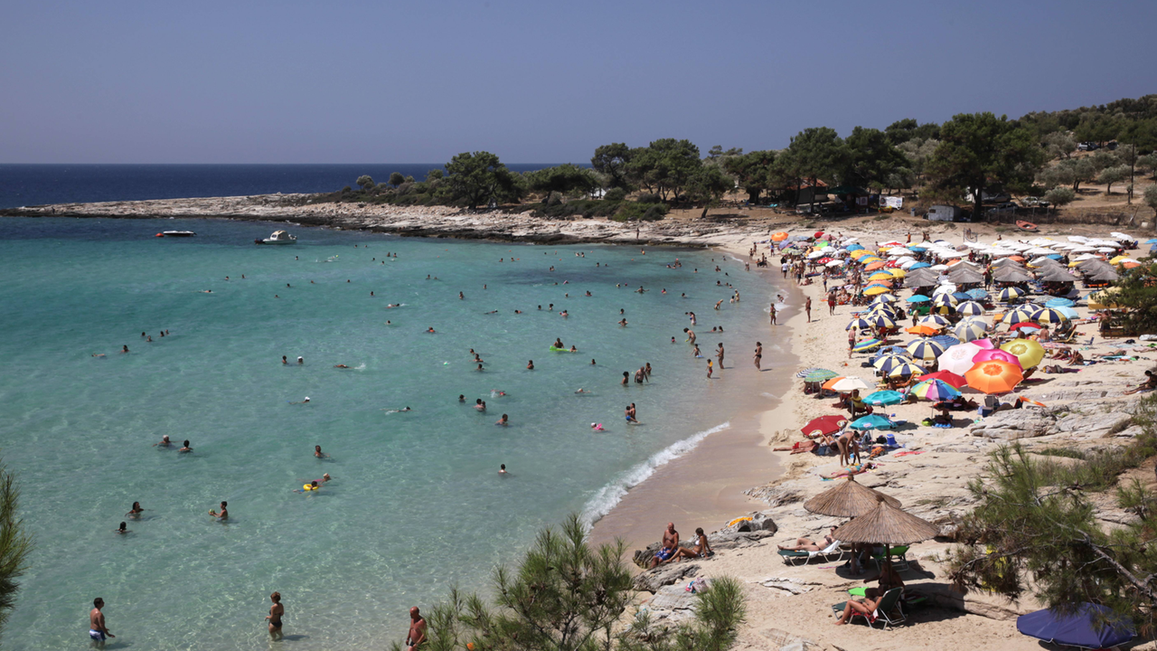 Viele Touristen liegen am Strand der griechischen Insel Thassos Viele Touristen liegen am Strand der griechischen Insel Thassos