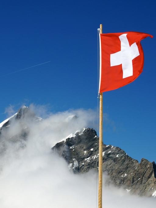 Die Schweizer Flagge weht nahe dem Jungfraujoch in den Berner Alpen in der Schweiz