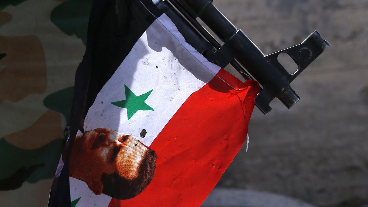 Ein Gewehr mit einer Fahne des syrischen Machthabers Baschar al-Assad