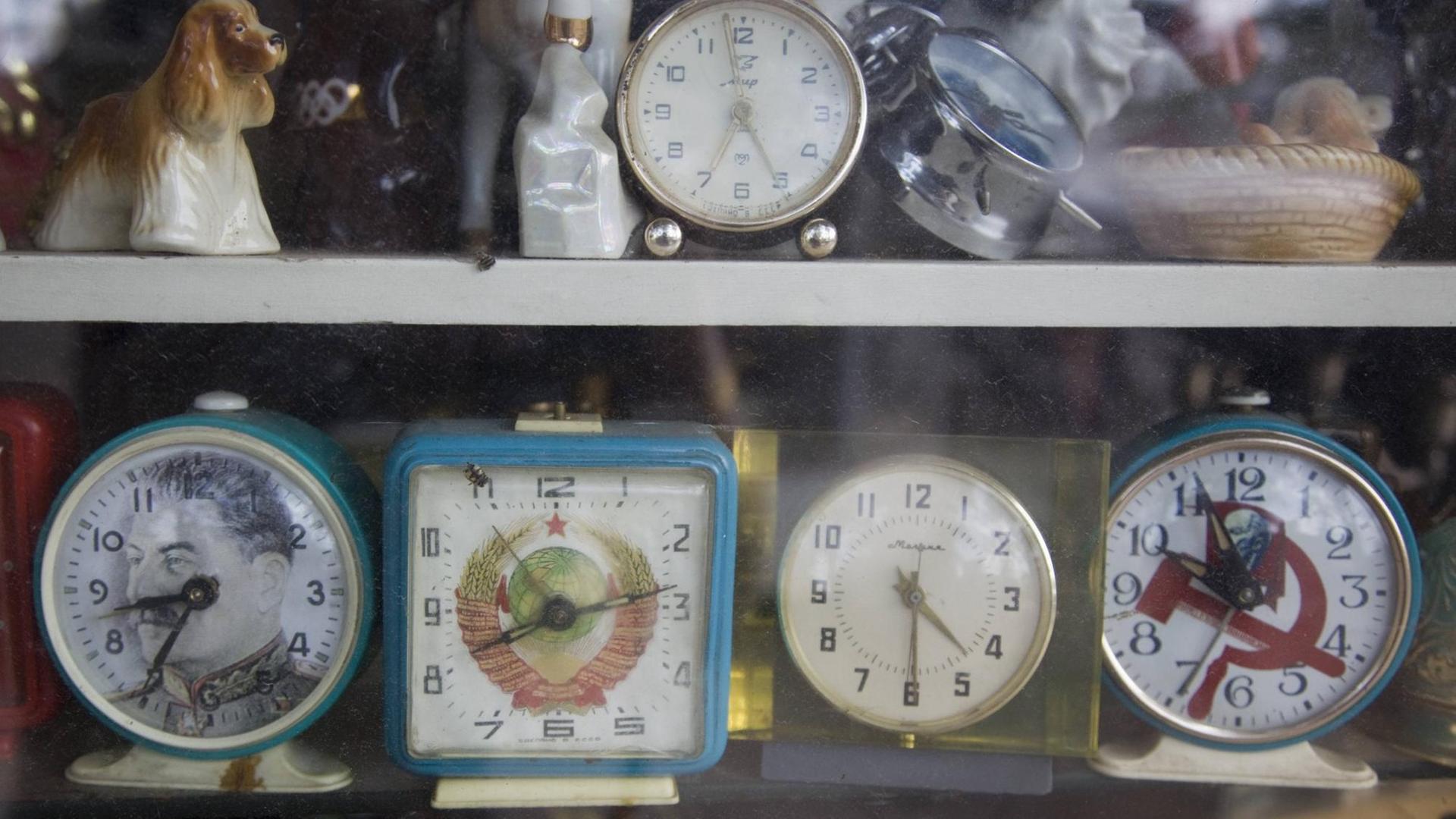 Wecker mit Stalin-Konterfei, Hammer und Sichel und anderen Sowjet-Symbolen an einem Kiosk. Wecker mit Stalin-Konterfei, Hammer und Sichel und anderen Sowjet-Symbolen an einem Kiosk.