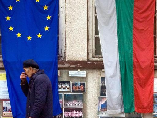 Ein Mann geht in Sofia an den Flaggen Bulgariens und der EU vorbei