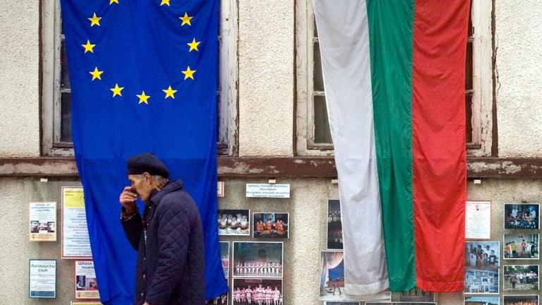 Ein Mann geht in Sofia an den Flaggen Bulgariens und der EU vorbei
