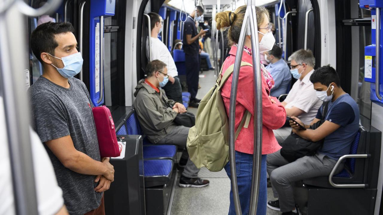 Passagiere in Lausanne tragen Mundschutz während einer Fahrt in der Metro. Passagiere in Lausanne tragen Mundschutz während einer Fahrt in der Metro.