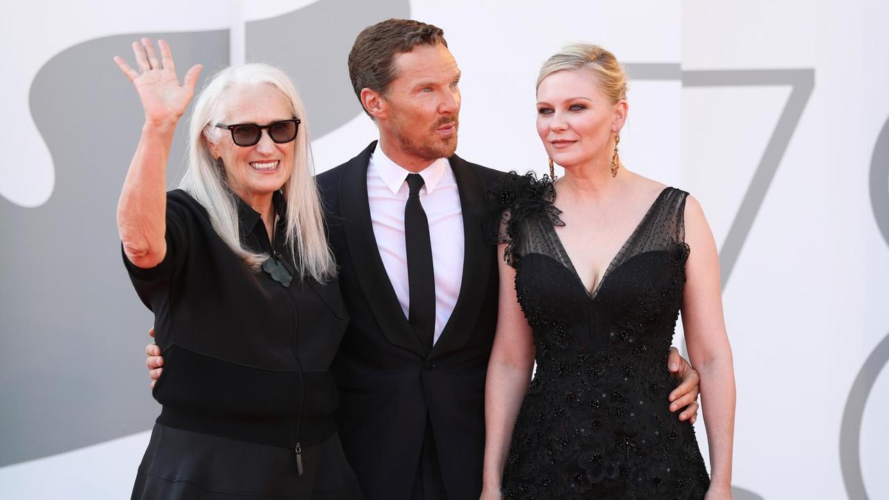 Die neuseeländische Regisseurin Jane Campion, der englische Schauspieler Benedict Cumberbatch und die amerikanische Schauspielerin Kirsten Dunst stehen auf dem roten Teppich bei den Internationalen Filmfestspielen von Venedig. Jane Campion winkt dem Publikum. Die neuseeländische Regisseurin Jane Campion, der englische Schauspieler Benedict Cumberbatch und die amerikanische Schauspielerin Kirsten Dunst stehen auf dem roten Teppich bei den Internationalen Filmfestspielen von Venedig. Jane Campion winkt dem Publikum.