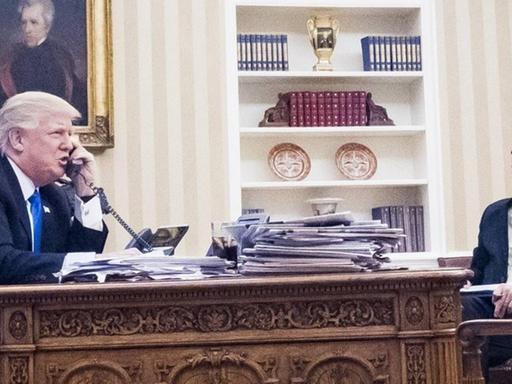 US-Präsident Donald Trump mit dem Nationalen Sicherheitsberater Michael Flynn and Chefberater Steve Bannon im Oval Office im Weißen Haus, Washington. Trump telefoniert mit dem australischen Premier Malcolm Turnbull am 28.1.2017.