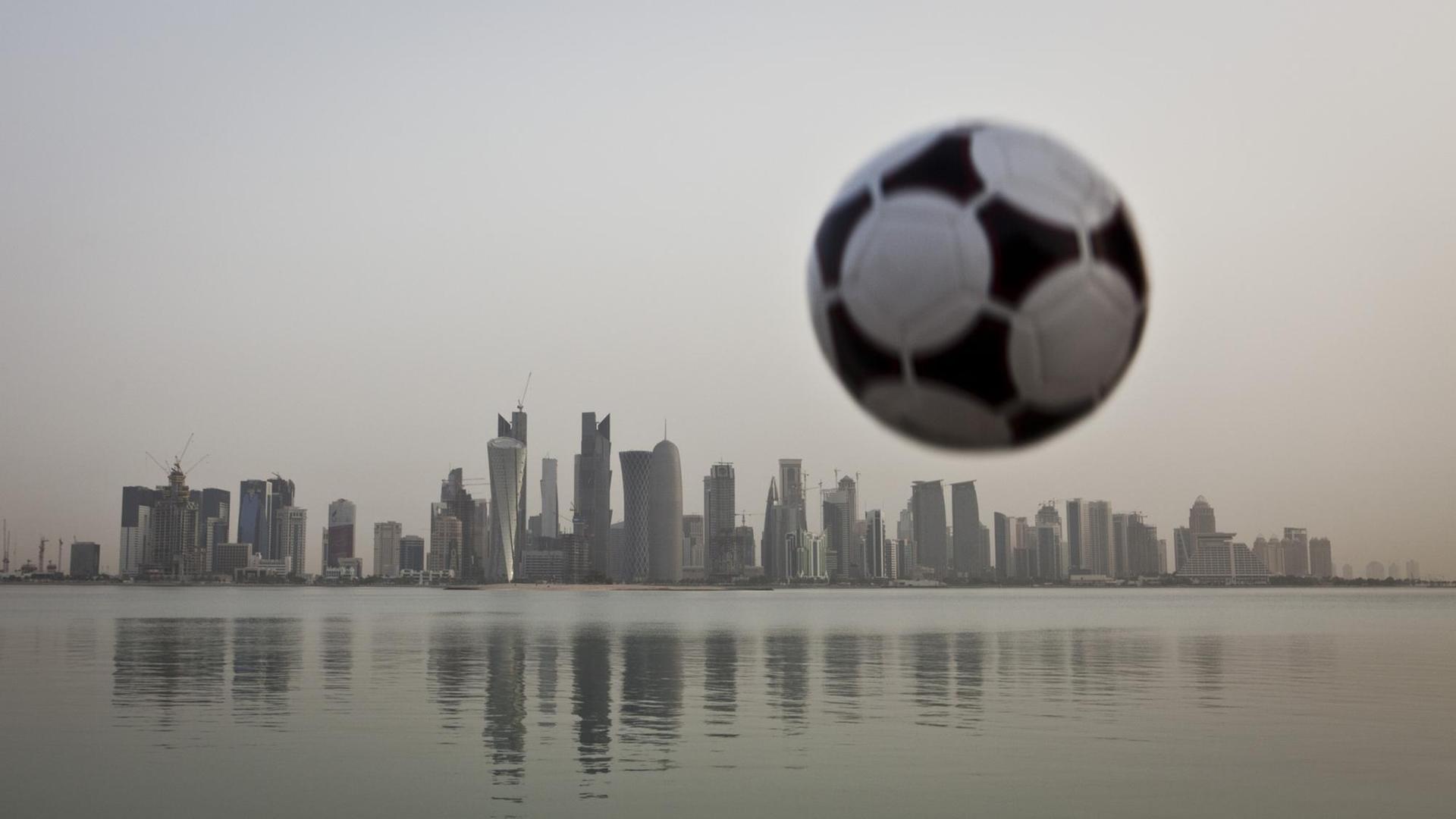 Ein Fußball über der Skyline von Doha, Emirat Katar Ein Fußball über der Skyline von Doha, Emirat Katar