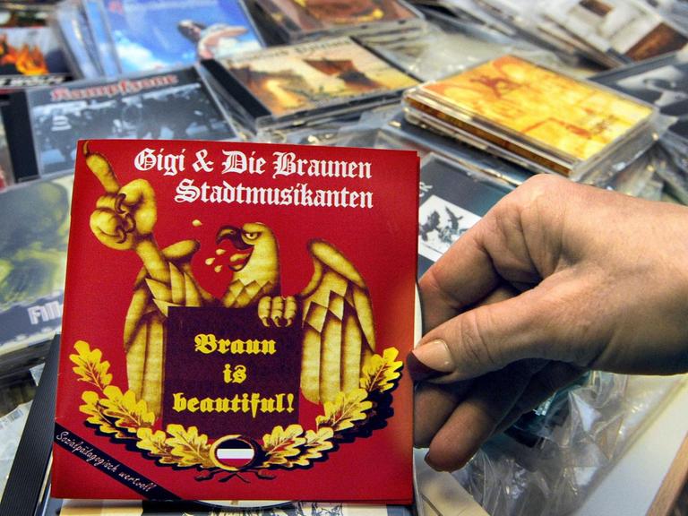 Eine Hand hält am 04.03.2009 im Polizeipräsidium in Stuttgart eine CD mit rechtsextremem Material in der Hand, die mit anderen Tonträgern bei Durchsuchungen sichergestellt wurde