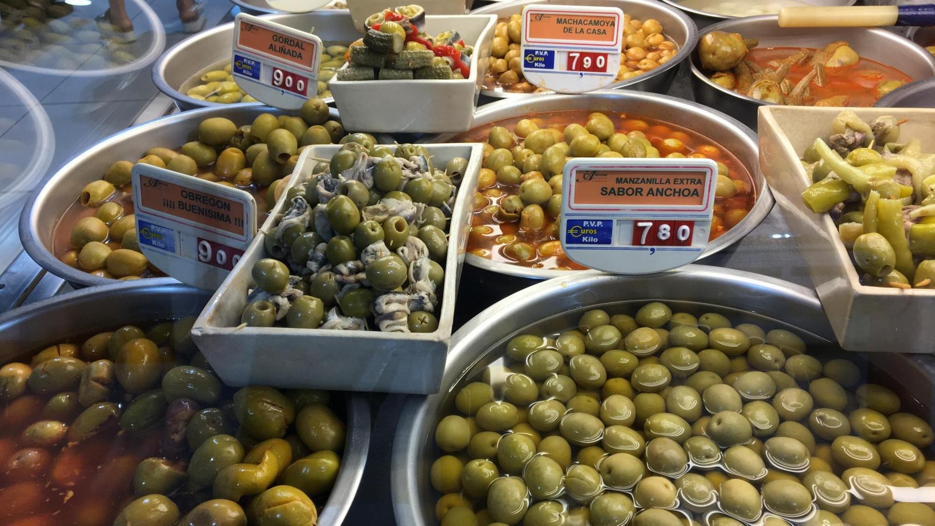 Eingelegte Oliven werden frisch in Schüsseln auf einem Verkaufsstand in der Markthalle "La Paz" von Madrid angeboten Eingelegte Oliven werden frisch in Schüsseln auf einem Verkaufsstand in der Markthalle "La Paz" von Madrid angeboten