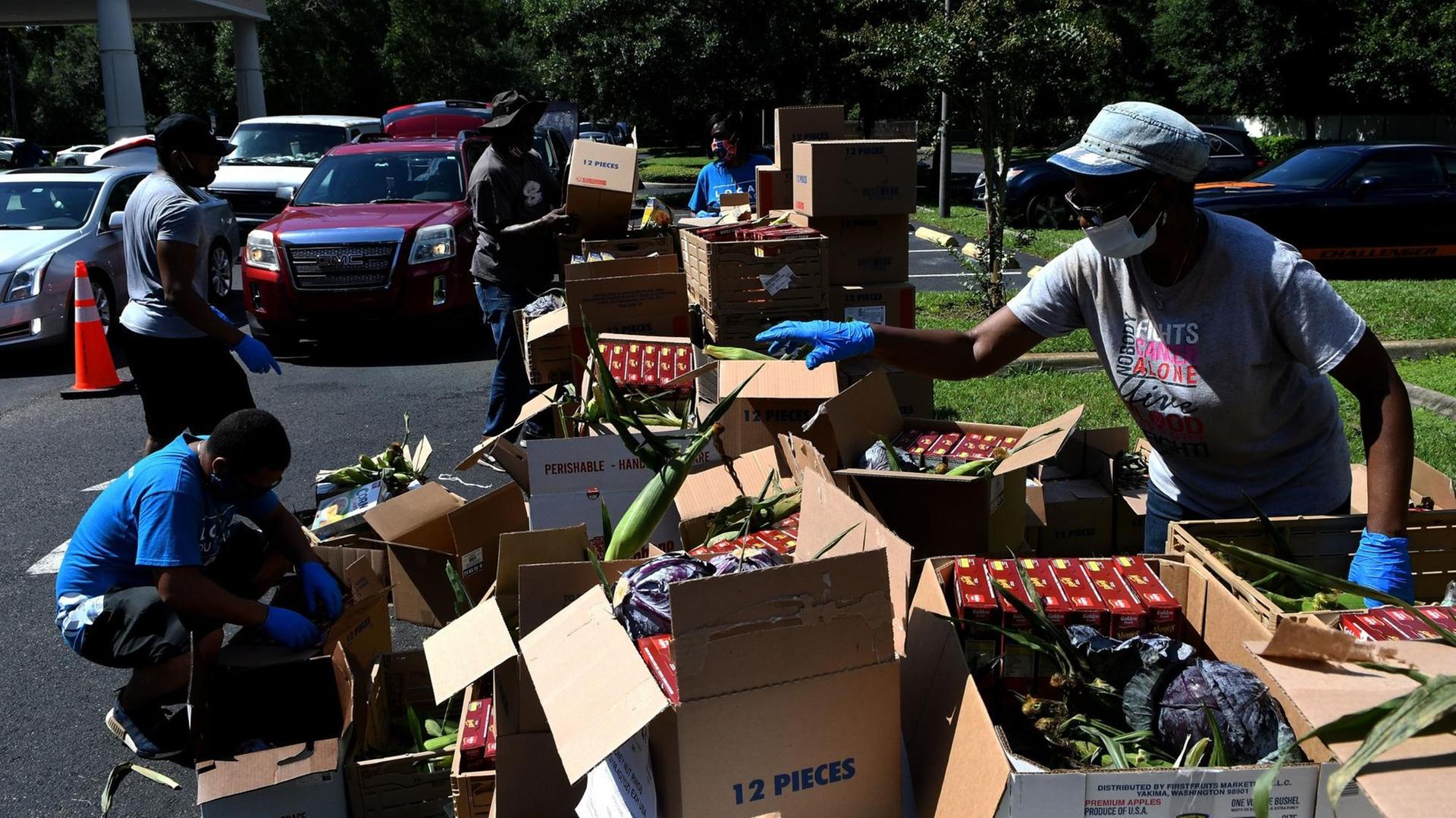 Freiwillige sortieren Lebensmittelspenden in Florida vor ihrer Verteilung. Freiwillige sortieren Lebensmittelspenden in Florida vor ihrer Verteilung.