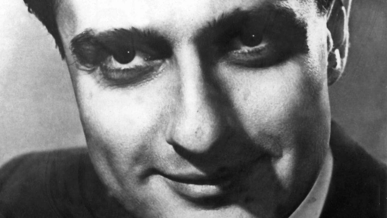 Zeitgenössische Aufnahme des rumänischen Pianisten und Komponisten Dino Lipatti, der mit nach hinten gegeltem Haar in die Kamera lächelt. Zeitgenössische Aufnahme des rumänischen Pianisten und Komponisten Dino Lipatti, der mit nach hinten gegeltem Haar in die Kamera lächelt.
