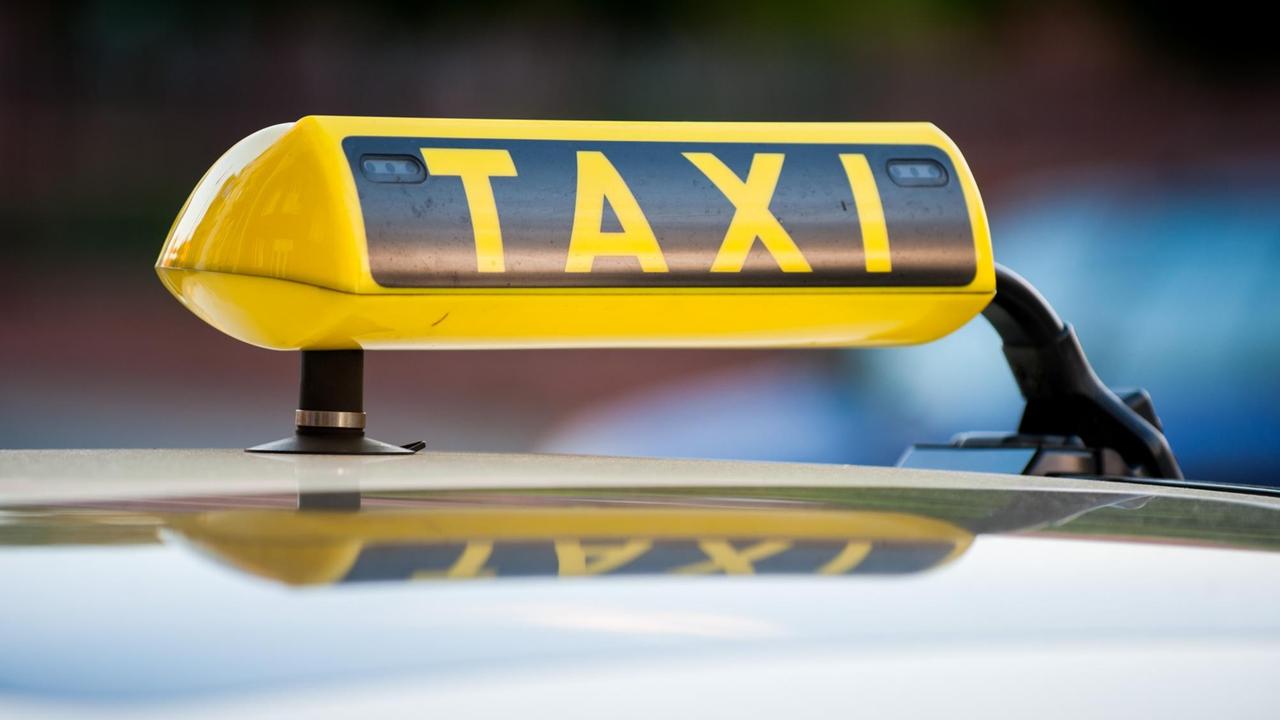 Ein Taxi-Schild auf einem Taxi in Berlin Ein Taxi-Schild auf einem Taxi in Berlin