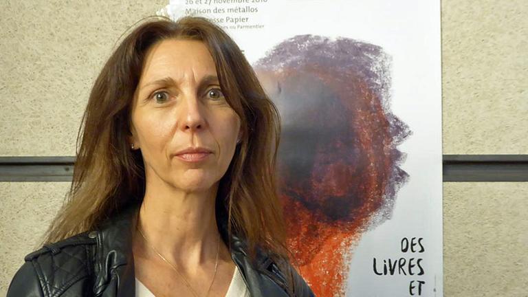 Stéphanie Gibaud steht vor einen Plakat. Stéphanie Gibaud steht vor einen Plakat.