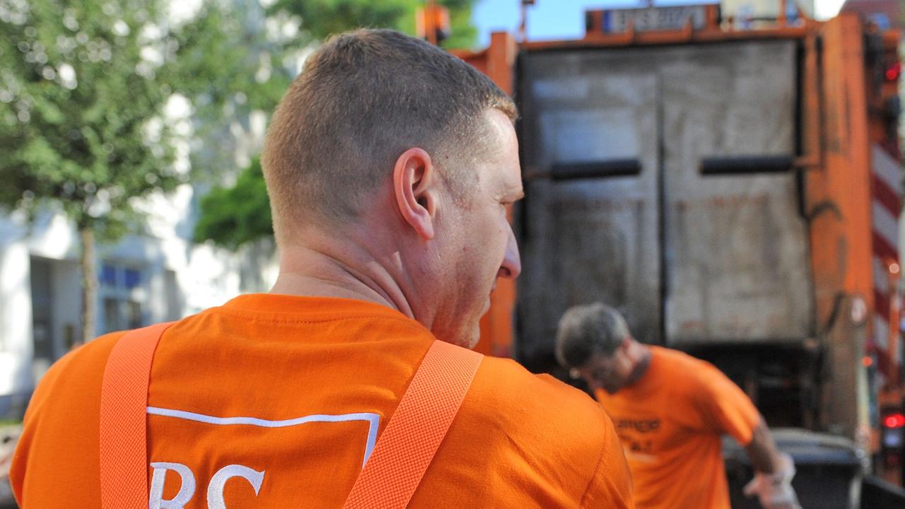 Mitarbeiter der Berliner Stadtreinigung (BSR) beim Entleeren von Mülltonnen Mitarbeiter der Berliner Stadtreinigung (BSR) beim Entleeren von Mülltonnen