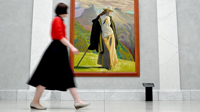Eine Frau geht an dem Gemälde "Bergsteigerin" des Künstlers Jens Ferdinand Willumsen in der Ausstellung "Wanderlust" in der Alten Nationalgalerie vorbei.