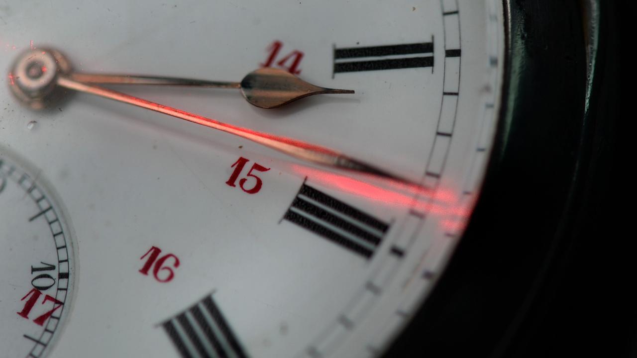 Ein roter Laserpointer markiert am 23.10.2014 in Ravensburg (Baden-Württemberg) auf einer alten Taschenuhr einen der Uhrzeiger, der für die Winterzeit neu gestellt werden muss. Am 26.10.2014 werden die Uhren um eine Stunde auf Winterzeit zurückgedreht.