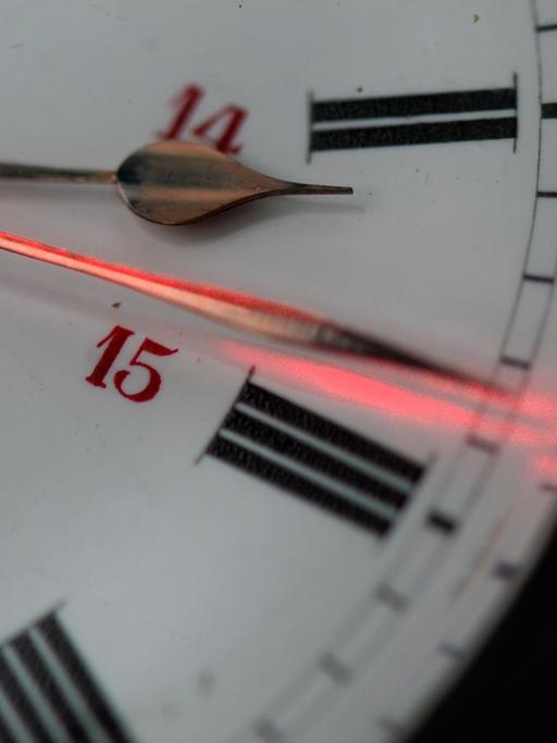 Ein roter Laserpointer markiert am 23.10.2014 in Ravensburg (Baden-Württemberg) auf einer alten Taschenuhr einen der Uhrzeiger, der für die Winterzeit neu gestellt werden muss. Am 26.10.2014 werden die Uhren um eine Stunde auf Winterzeit zurückgedreht.