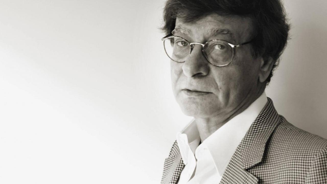 Der palästinensische Lyriker Mahmud Darwish in einem Schwarzweißfoto. Er trägt einen grauen Anzug. Der palästinensische Lyriker Mahmud Darwish in einem Schwarzweißfoto. Er trägt einen grauen Anzug.