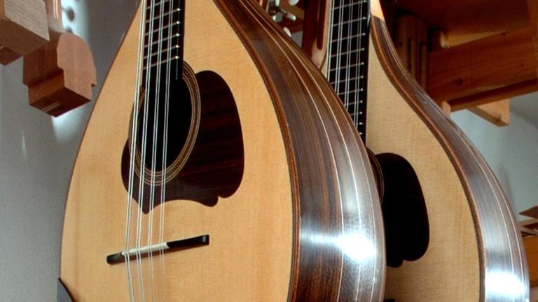 Zwei Mandolinen hängen an der Wand. Zwei Mandolinen hängen an der Wand.