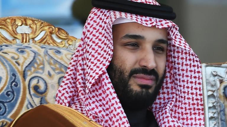 Mohammed bin Salman sitzt in traditioneller Kopfbedeckung auf einem Sessel. Mohammed bin Salman sitzt in traditioneller Kopfbedeckung auf einem Sessel.