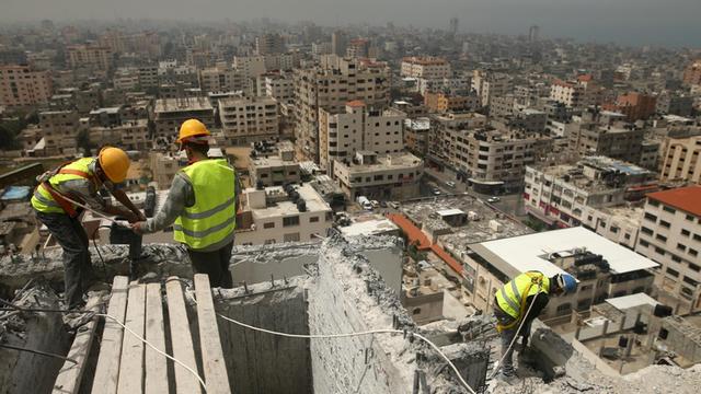 Palästinensische Bauarbeiter räumen Trümmer in Gaza-Stadt weg. Während des 50 Tage andauernden Krieges zwischen Israel und der Hamas im Sommer 2014 wurden dort viele Häuser zerstört.