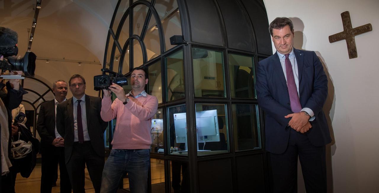 Markus Söder, Bayerischer Ministerpräsident (CSU), steht im Eingangsbereich der bayerischen Staatskanzlei neben einem Kreuz, das er kurz zuvor aufgehängt hat Markus Söder, Bayerischer Ministerpräsident (CSU), steht im Eingangsbereich der bayerischen Staatskanzlei neben einem Kreuz, das er kurz zuvor aufgehängt hat