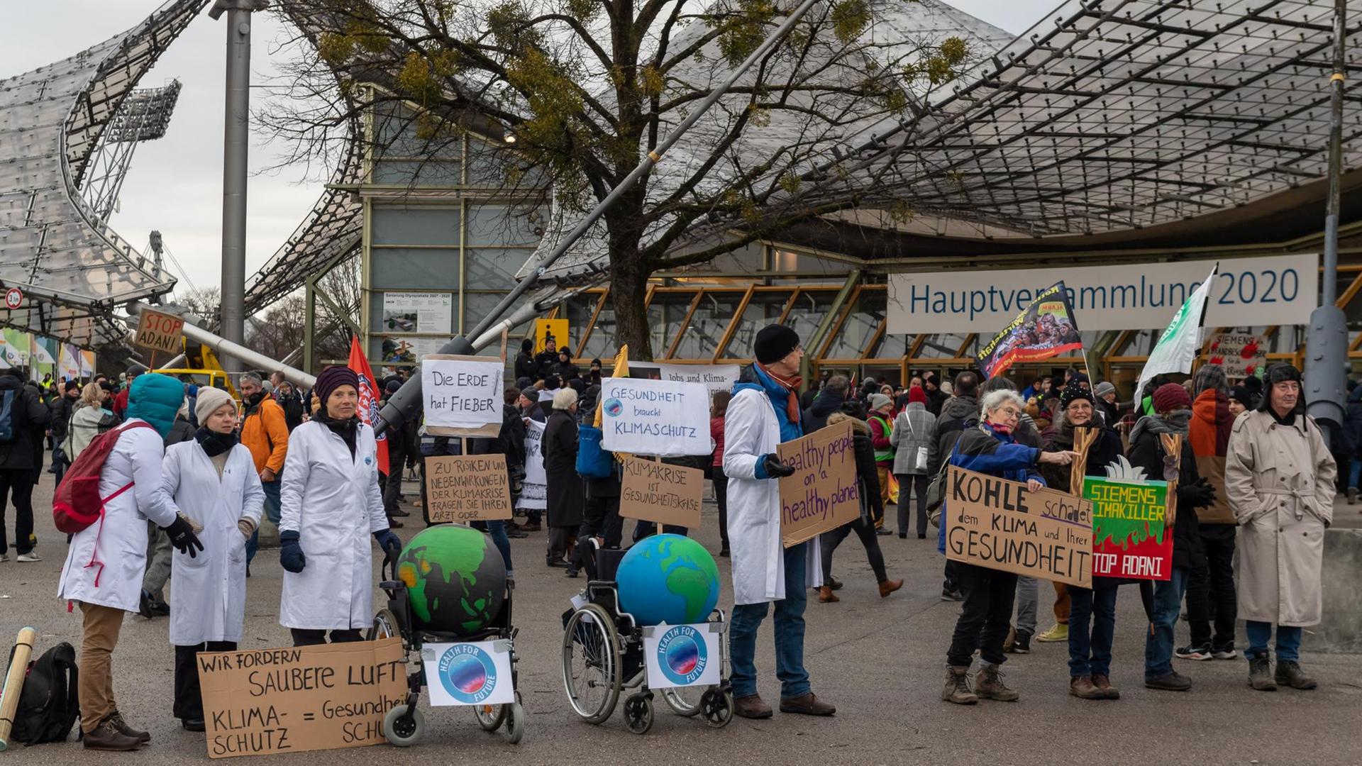 Klimaaktivisten demonstrieren mit Plakaten am Haupteingang zu Beginn der Siemens-Hauptversammlung vor der Olympiahalle in München. Klimaaktivisten demonstrieren mit Plakaten am Haupteingang zu Beginn der Siemens-Hauptversammlung vor der Olympiahalle in München.