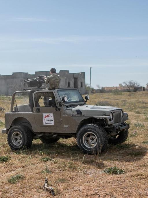 Ein Kämpfer der international anerkannten Regierung feuert ein schweres Maschinengewehr auf die Streitkräfte der selbsternannten Libyschen Nationalen Armee. 