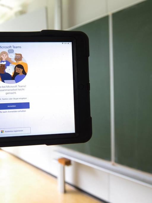 Ein Tablet mit Microsoft Teams vor einer Tafel in einem leeren Klassenzimmer 