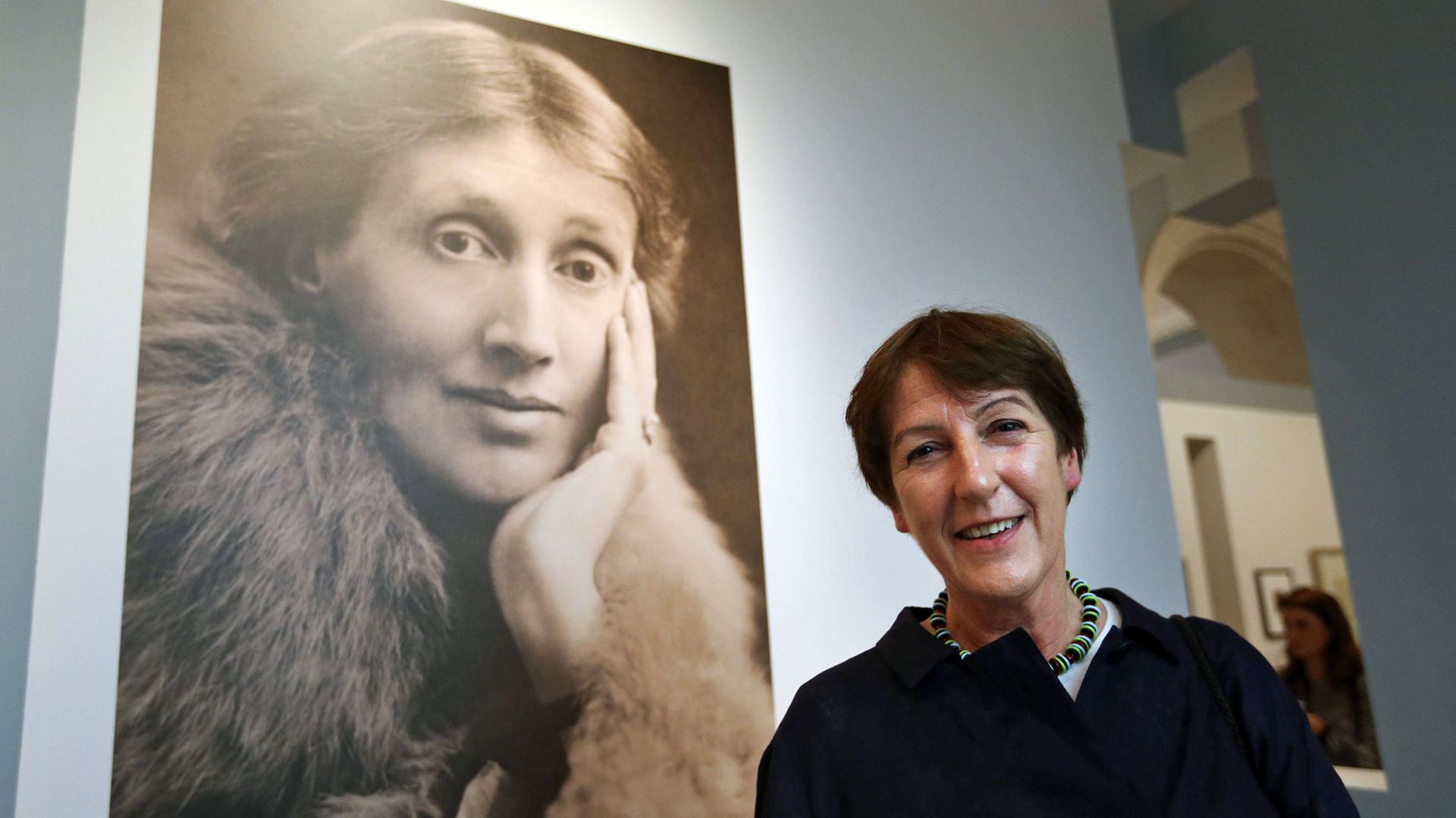 Die Kunsthistorikerin Frances Spalding neben einem Porträt der Schriftstellerin Virginia Woolf, aufgenommen am 9.7.2014 in der Virginia-Woolf-Ausstellung in der National Portrait Gallery in London, die von ihr kuratiert wurde.