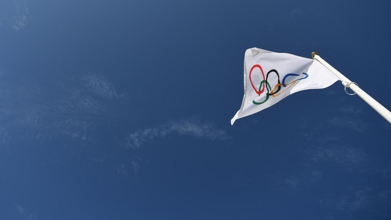 Eine olympische Flagge weht an einem Fahnenmast. Eine olympische Flagge weht an einem Fahnenmast.