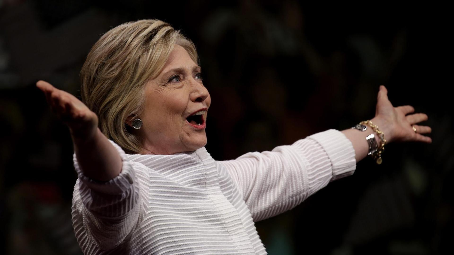 Hillary Clinton breitet die Arme weit aus. Hillary Clinton breitet die Arme weit aus.