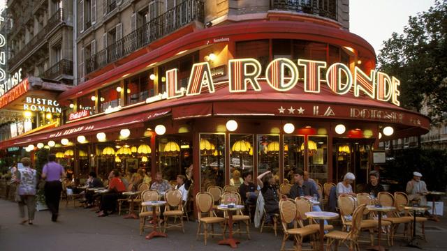 Besucher vor dem Café La Rotonde in Paris am Abend