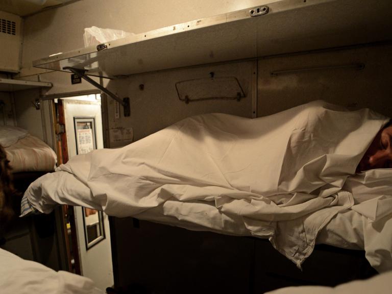 Ein Mann schläft im Nachtzug von St. Petersburg nach Moskau.