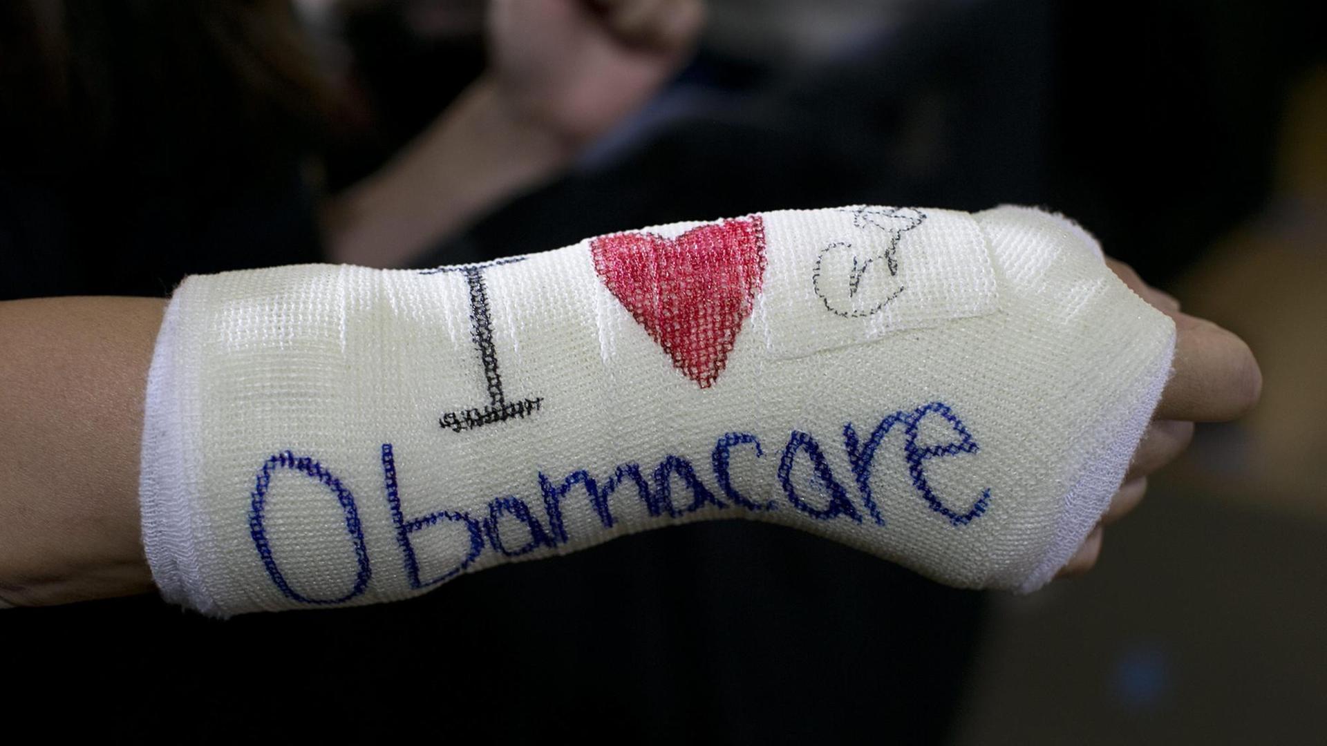 Ein eingegipster Unterarm, auf dem "I love Obamacare" steht Ein eingegipster Unterarm, auf dem "I love Obamacare" steht