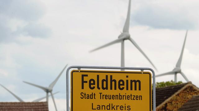 Hinter dem Ortsschild von Feldheim (Brandenburg) drehen sich die Windräder. In dem Ortsteil von Treuenbrietzen (Potsdam-Mittelmark) können die 145 Einwohner sich selbst mit Strom und Wärme versorgen - erzeugt aus Windkraft- und Biogasanlagen.