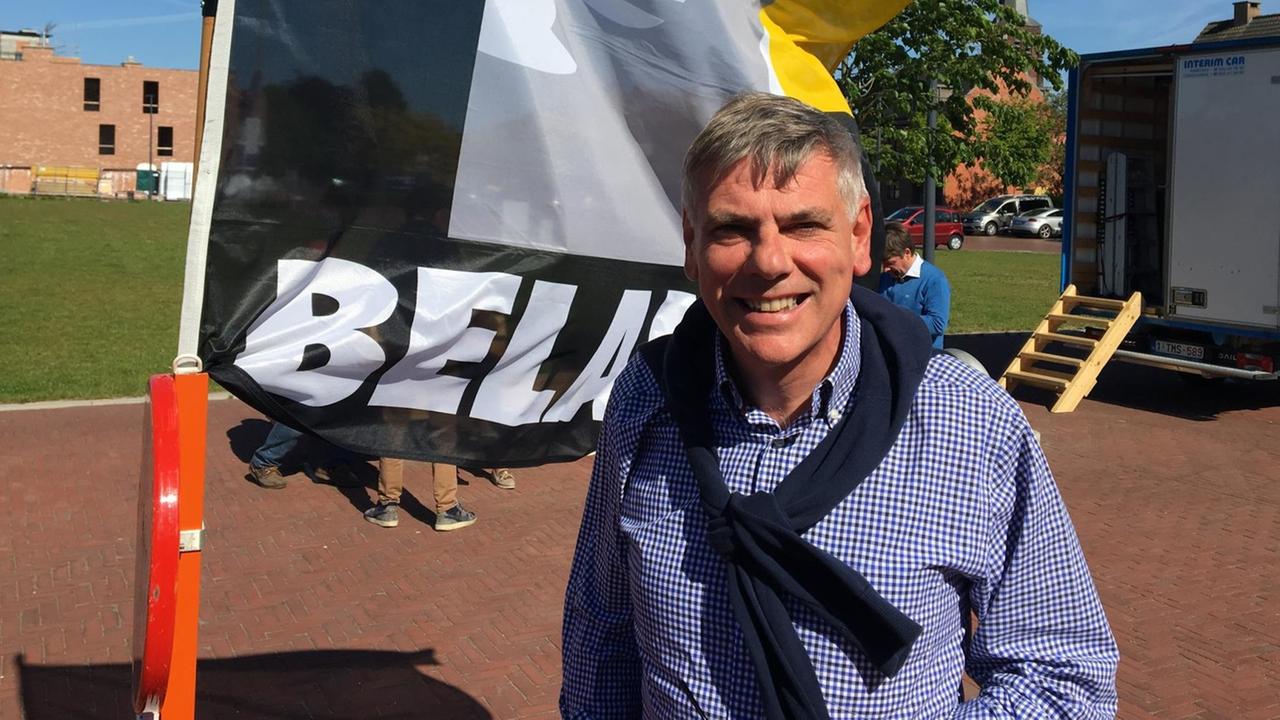 Mann stehend vor der Partei-Flagge Mann stehend vor der Partei-Flagge