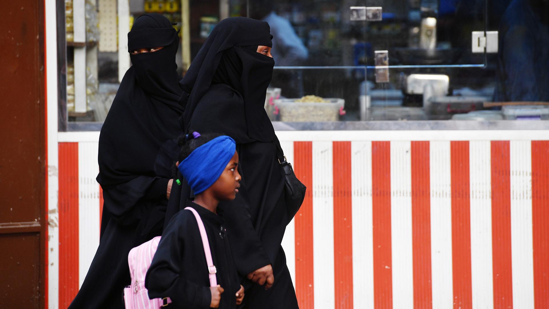 Zwei Frauen und ein Kind laufen durch die City von Jeddah in Saudi-Arabien Zwei Frauen und ein Kind laufen durch die City von Jeddah in Saudi-Arabien