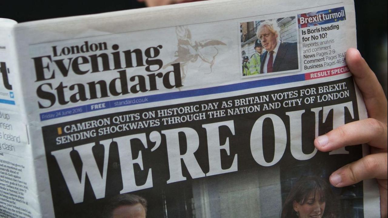 Nach der Brexit-Entscheidung: Ein Mann hällt die Zeitung London Evening Standard in der Hand. Zu sehen ist das Titelblatt. Darauf steht: "We're Out", wir sind draußen. Nach der Brexit-Entscheidung: Ein Mann hällt die Zeitung London Evening Standard in der Hand. Zu sehen ist das Titelblatt. Darauf steht: "We're Out", wir sind draußen.