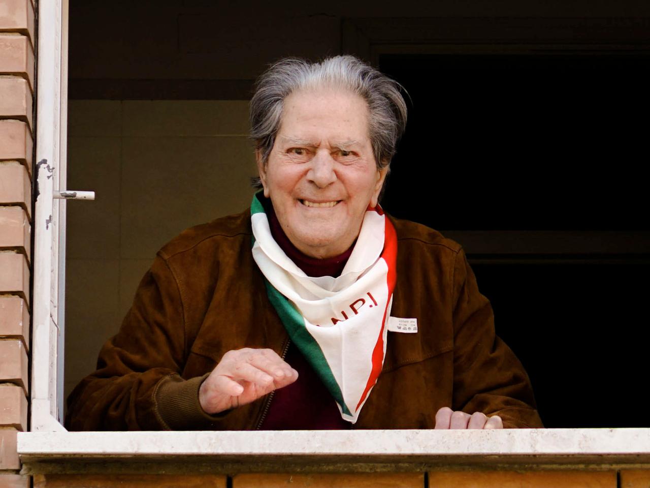 Der alte Mann lächelt am Fenster, er hat ein grün-weiß-rotes Halstuch mit dem Logo der Partisanen-Organisation ANPI umgebunden.