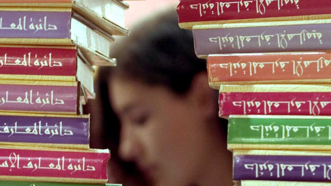 Hinter einer islamischen Enzyklopädie liest eine Besucherin auf der Frankfurter Buchmesse 2004 in der Halle der "Arabischen Welt". Hinter einer islamischen Enzyklopädie liest eine Besucherin auf der Frankfurter Buchmesse 2004 in der Halle der "Arabischen Welt".