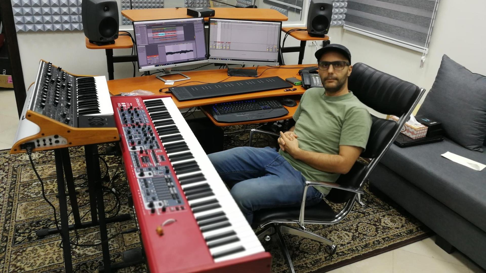 Friedensaktivist und Musiker Kayed Sagalla sitzt im Studio des Zivilen Friedensdienstes in Ramallah, umgeben von Keyboards, Mikros und Synthesizern