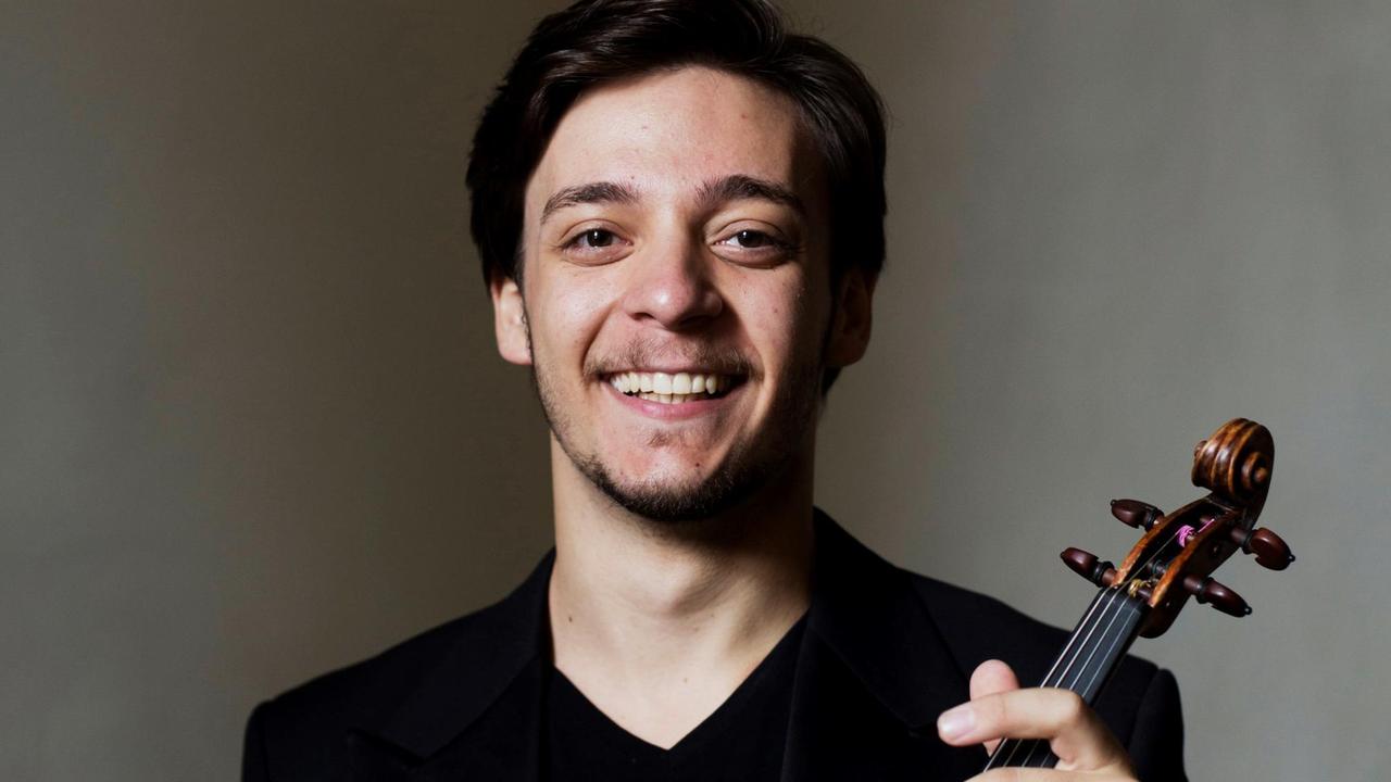 Der Musiker Andrea Obiso hält seine Geige in den Händen. Der Musiker Andrea Obiso hält seine Geige in den Händen.