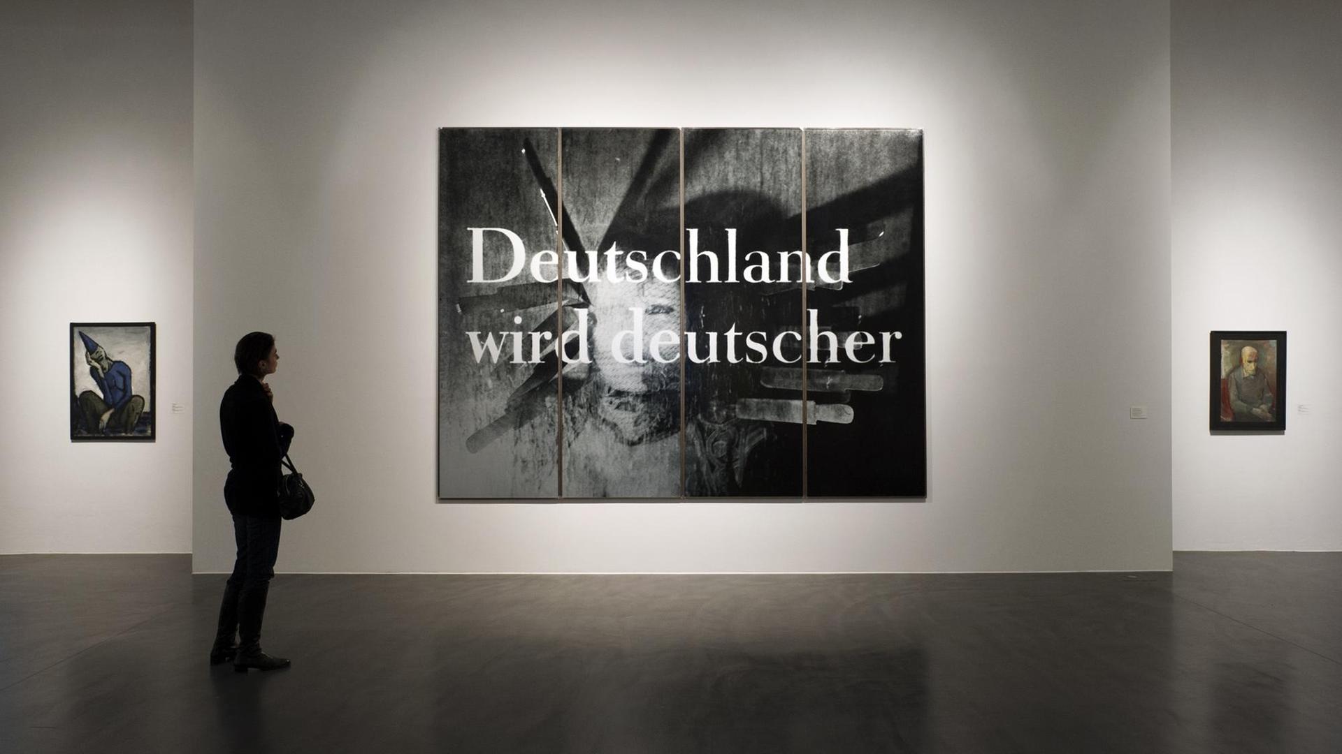 Eine Frau betrachtet das Bild "Deutschland wird deutscher" von Katharina Sieverding (1992-Siebdruck auf Metall) in der Ausstellung "geteilt | ungeteilt Kunst in Deutschland 1945 bis 2010" in der Galerie Neue Meister in Dresden (02/2012 bis 08/2013) Eine Frau betrachtet das Bild "Deutschland wird deutscher" von Katharina Sieverding (1992-Siebdruck auf Metall) in der Ausstellung "geteilt | ungeteilt Kunst in Deutschland 1945 bis 2010" in der Galerie Neue Meister in Dresden (02/2012 bis 08/2013)