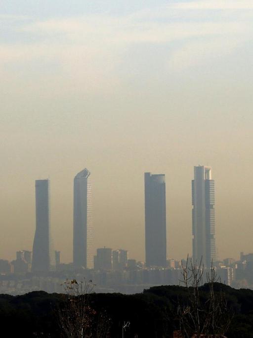 epa05054185 A view of Madrid's skyline under a visible cloud of smog provoked by the high pollution in the city, Spain, 04 December 2015. New high levels of NO2 (nitrogen dioxide) have raised the contamination alert and reactivated emergency measures including traffic restrictions. Madrid's polluted atmosphere is under constant surveillance as NO2 levels keep rising due to general good weather and lack of rain or wind recently. Traffic restrictions will continue until NO2 levels drop. EPA/SERGIO BARRENECHEA |