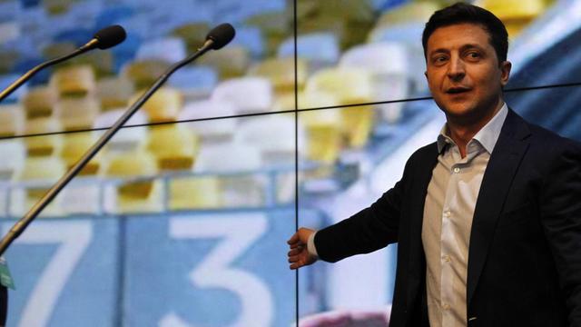 Der künftige Präsident der Ukraine, Selenskyj, am Wahlabend vor einer Leinwand, auf der in ukrainischen Farben das Wahlergebnis angezeigt wird.