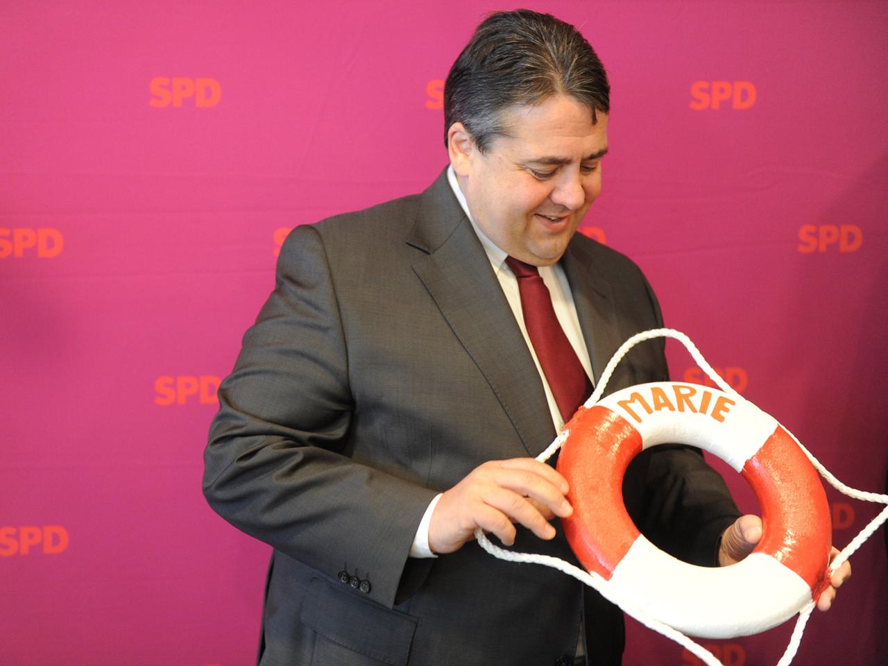 Der SPD-Parteivorsitzende Sigmar Gabriel hält am Montag (23.04.2012) in Kiel zu Beginn der SPD-Bundesvorstandssitzung ein Geschenk, einen Rettungsring mit dem Namen seiner neugeborenen Tochter Marie, hoch.