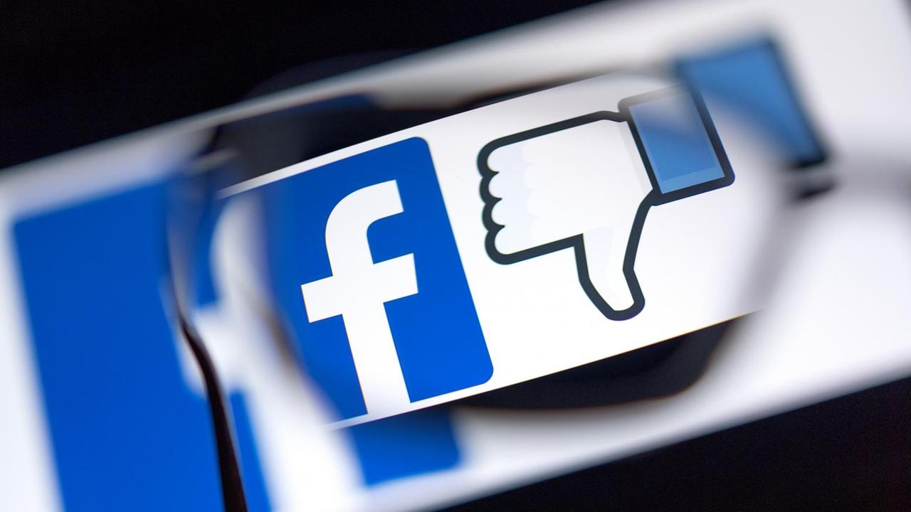 Das Logo des sozialen Netzwerks Facebook und das Zeichen für "Gefällt mir nicht" (Daumen runter) werden auf einem Bildschirm angezeigt. Das Logo des sozialen Netzwerks Facebook und das Zeichen für "Gefällt mir nicht" (Daumen runter) werden auf einem Bildschirm angezeigt.
