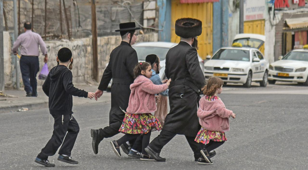 Eine orthodoxe Familie überquert in Jerusalem eine Straße. Eine orthodoxe Familie überquert in Jerusalem eine Straße.