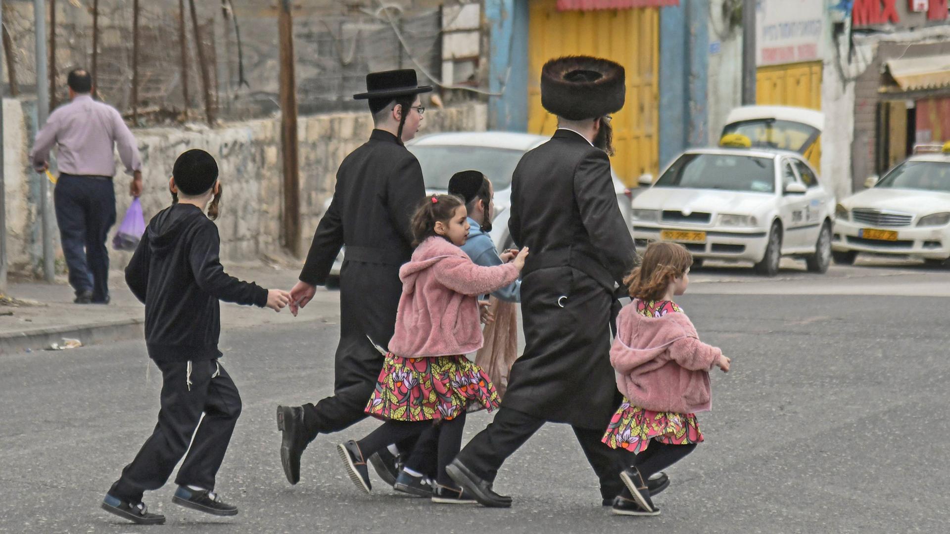 Eine orthodoxe Familie überquert in Jerusalem eine Straße. Eine orthodoxe Familie überquert in Jerusalem eine Straße.