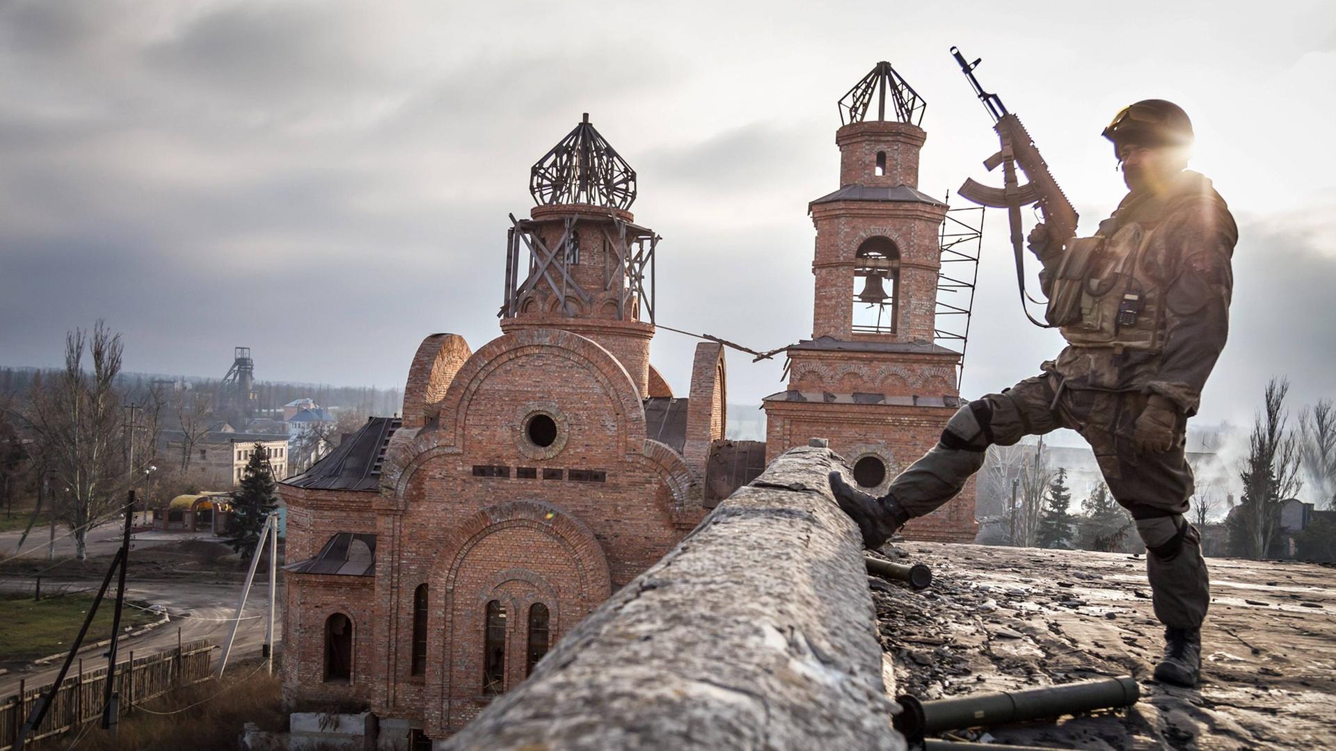 Soldat vor zerstörter Kirche im ukrainischen Dorf Pisky. Soldat vor zerstörter Kirche im ukrainischen Dorf Pisky.